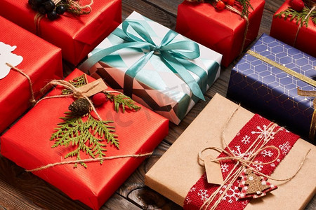 创造性地包装和装饰圣诞礼物在木背景的盒子顶视图从上面.平放。 