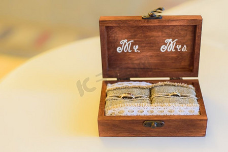 桌上印有字母的木盒结婚戒指枕头粗麻布