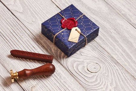 创意包装和装饰的圣诞礼物盒子和白色木质背景上的蜡封印章