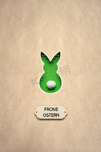 兔尾巴摄影照片_有创意的复活节概念照片，一只棕色背景的纸做的兔子。弗隆·奥斯特恩。