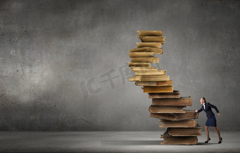 提高你的教育水平。决心坚定的女商人爬上一堆书