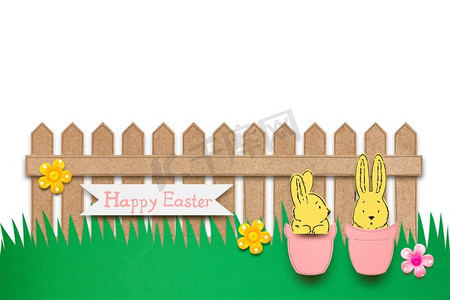白底白纸围栏前花盆里兔子的创意复活节概念照片。