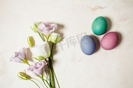 粉色梅布背景上的鲜花和鸡蛋，复制复活节问候的空间。鲜花和鸡蛋