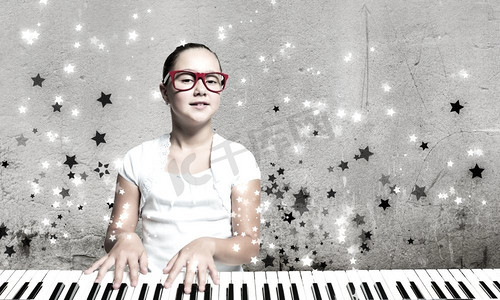 女学生弹钢琴漂亮的学校女孩在有趣的眼镜弹钢琴
