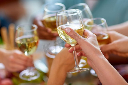 酒杯干杯摄影照片_庆祝、饮食和度假的概念-手碰酒杯。手握酒杯