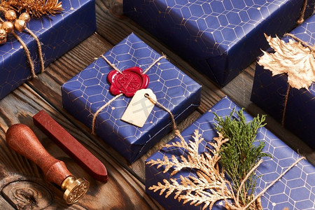 创造性地包装和装饰圣诞礼物，在木质背景的盒子里。平躺着。
