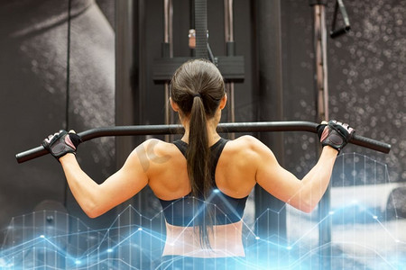 运动,健身,健美,生活方式和人的概念-女性在健身房的电缆机上锻炼肌肉