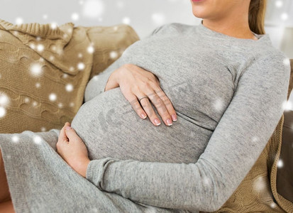怀孕，人和母亲的概念--雪地里肚子大的孕妇的特写。大腹便便的孕妇特写