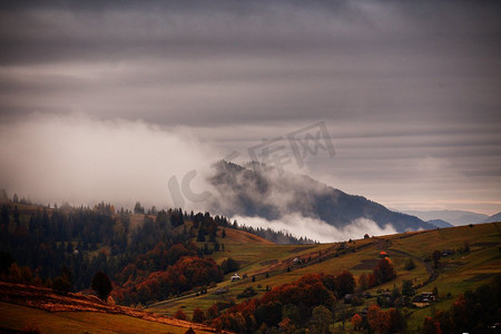 缤纷天空摄影照片_山上秋景，林木缤纷。云雾中的高山就是背景。山上的村庄。