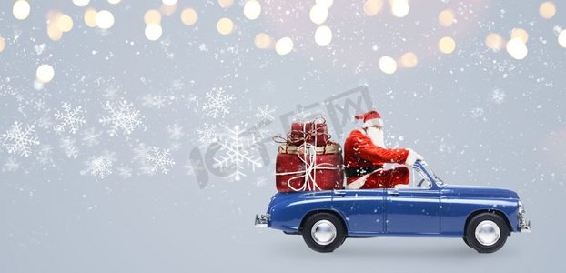 车里的圣诞老人。汽车上的圣诞老人在雪灰色的背景下送圣诞或新年礼物