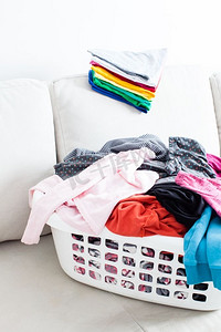 洗好的衣服放在篮子里，干净的床单放在沙发上。彩色洁净服