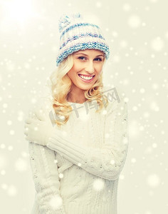 冬天、时尚、圣诞节和人们的概念--戴着冬帽、毛衣和手套微笑的年轻女子。戴着冬帽、穿着毛衣的微笑年轻女子