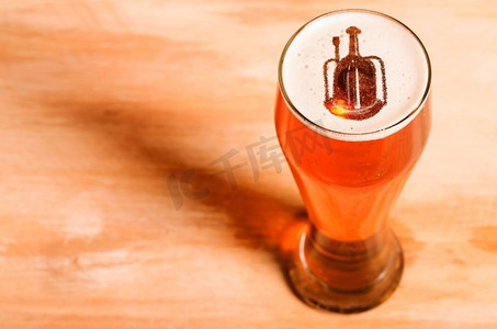本地精酿啤酒。啤酒厂的剪影在酒吧桌子上的一杯新鲜啤酒中，从高处俯瞰。本地精酿啤酒