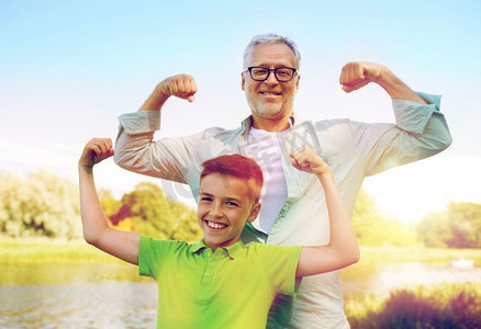 家庭、世代、权力和人民观念-快乐的祖父和孙子展示肌肉。快乐的爷爷和孙子展示肌肉
