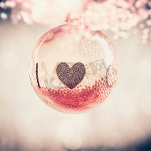 红色玻璃圣诞挂球，带心形背景，节日贺卡