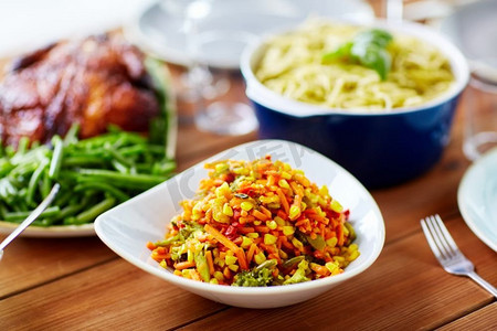 玉米沙拉摄影照片_食物，饮食和烹饪概念-在木桌上放一碗蔬菜沙拉和玉米。餐桌上有玉米和其他食物的蔬菜沙拉