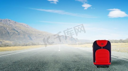 红色行李箱在路上。红色行李箱上路的旅行理念
