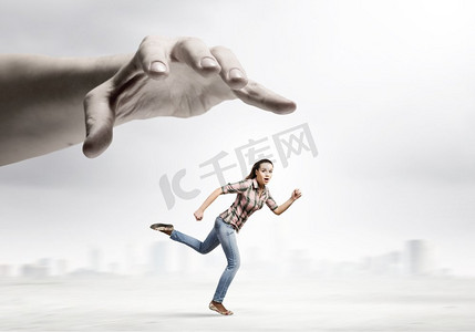 压迫者摄影照片_奔跑的女人年轻女子在休闲逃脱大男性的手