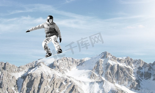 跳高摄影照片_滑雪运动。滑雪板使跳高在晴朗的蓝天