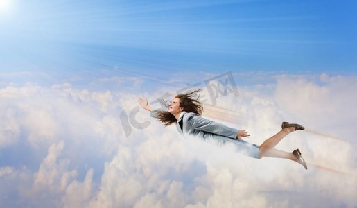 女超人摄影照片_会飞的女商人。一位意志坚定的年轻女商人，在天空中飞翔