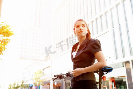 骑自行车上下班的年轻女子。在城市里骑自行车上下班的年轻商务女性