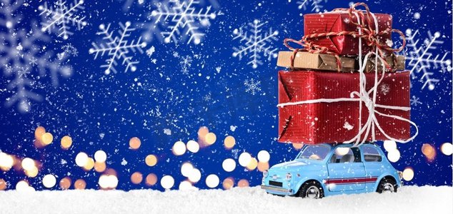 带有圣诞礼物的复古玩具车。复古玩具车，在节日蓝色背景下递送圣诞或新年礼物