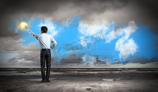 男人站着背抚着太阳.