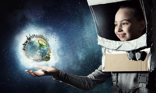 我要探索太空。头戴纸盒头盔的可爱女孩梦想成为宇航员。这张图片的要素由美国宇航局提供