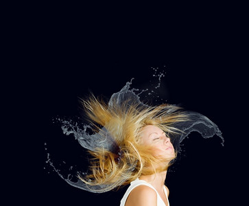 飞溅火焰摄影照片_头发护理。年轻有吸引力的金发女子与头发在飞溅