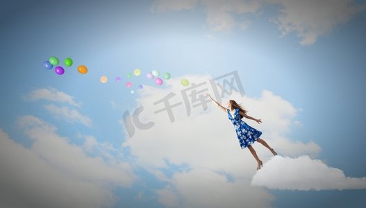 天空中飞翔摄影照片_快乐的年轻女子梦想着在天空中飞翔。自由的伟大一天