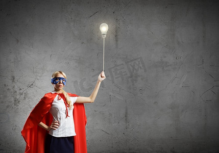 超女。穿着超级英雄服装的年轻女子手里拿着灯泡气球