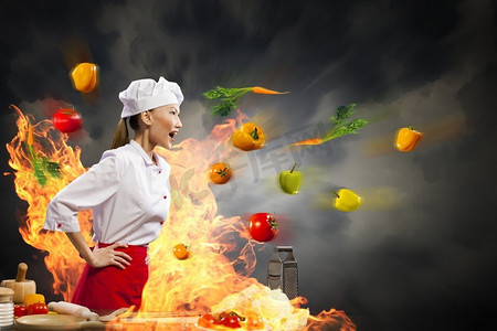 女性生气摄影照片_亚洲女厨师在愤怒。愤怒的亚洲女性厨师与飞行蔬菜反对与闪耀效果的颜色背景