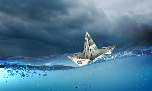 漂浮在水面上摄影照片_纸船。风浪中漂浮在水面上的纸船