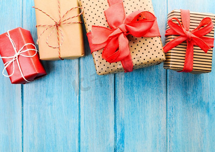 新年新年礼盒摄影照片_圣诞或新年手工礼物。蓝色木质背景的圣诞或新年装饰礼盒