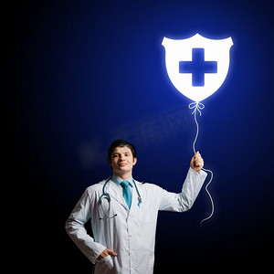 男医生。年轻男医生手持带有医学标志的气球