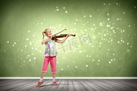 拉小提琴的女孩。在绿色背景下拉小提琴的可爱女孩形象