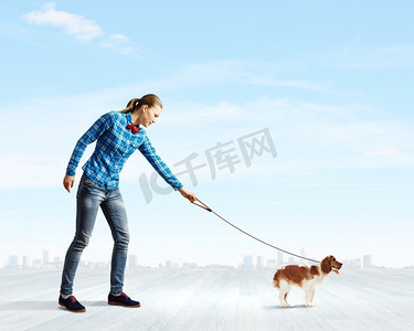 养狗的女人。牵着狗随意散步的年轻女子