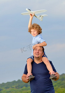 父亲把儿子和他的飞机扛在肩上
