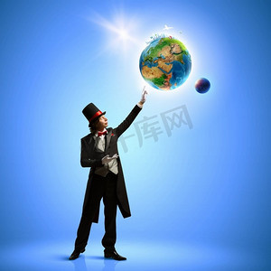 拿着地球仪的魔术师。戴着帽子的魔术师的形象。生态观。这张图片的要素由美国宇航局提供