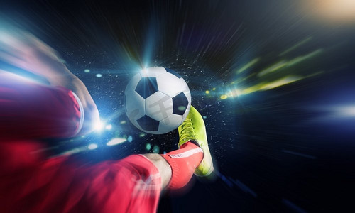 足球腿摄影照片_踢足球。近摄足球运动员的脚踢的球的形象
