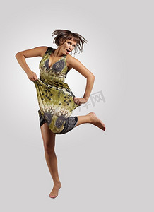古女子摄影照片_年轻女子又跳又跳……非常现代、苗条的嘻哈风格的女人在彩色背景上跳着舞