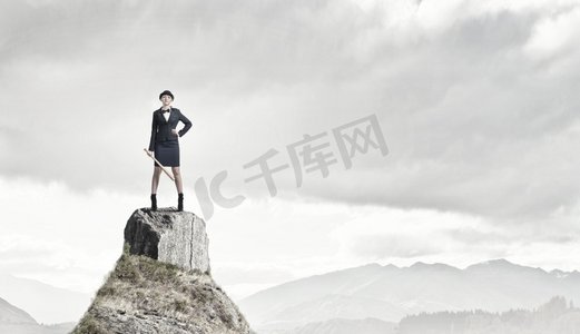 棒球棍摄影照片_拿着棒球棍的女人。年轻漂亮的女人穿着西装，戴着帽子，拿着棒球棍