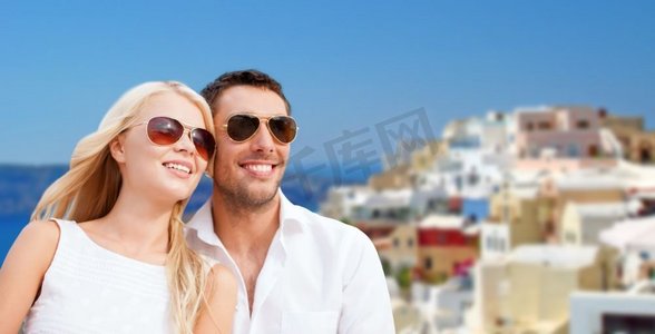 旅游、旅游和暑假概念-快乐的情侣拥抱圣托里尼岛背景。戴墨镜的幸福夫妇在圣托里尼岛上空