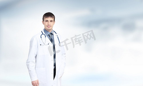 自信的医生年轻英俊的医生与听诊器反对白色背景