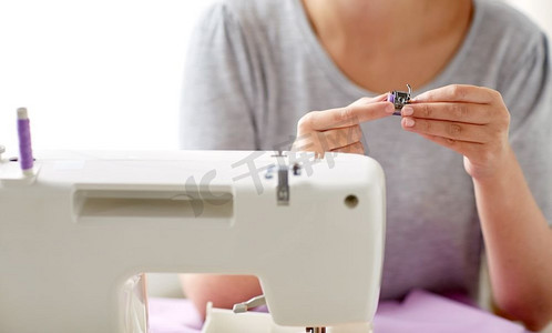 人，针线活和裁剪概念-工作室里用缝纫机的线和卷轴裁剪的女人。带缝纫机卷轴的女裁缝