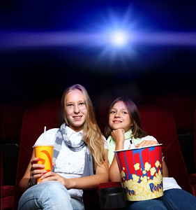 两个年轻女孩看电影在电影院