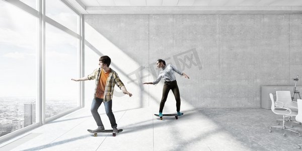 男孩骑滑板。活跃的家伙在办公室内部玩滑板。混合介质
