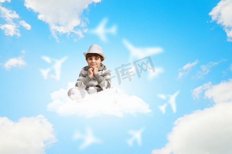 小男孩在做梦。小男孩坐在云上放松的形象