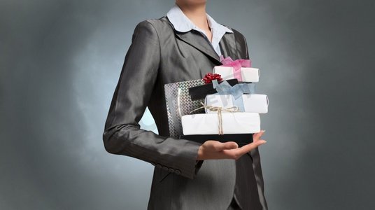 女商人接受或赠送礼物的女商人。近距离观察女商人，手里拿着成堆的礼品盒