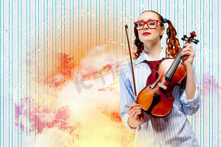 年轻的女小提琴家。彩色背景下拿着小提琴的年轻滑稽女子形象